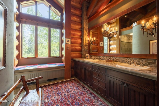 1525 S Thunder Rd, Wilson, WY 83014 - bathroom featuring rustic walls, double vanity, vaulted ceiling, a chandelier, and decorative backsplash