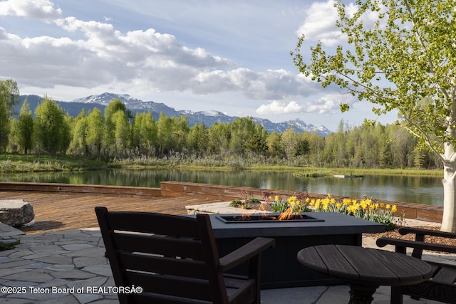 1525 S Thunder Rd, Wilson, WY 83014 - view of patio / terrace featuring a fire pit, a wooded view, and a water and mountain view