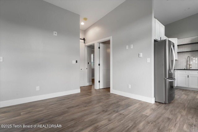 138 Larkspur Ave Unit 402, Victor, ID 83455 - unfurnished living room featuring a barn door, wood finished floors, and recessed lighting