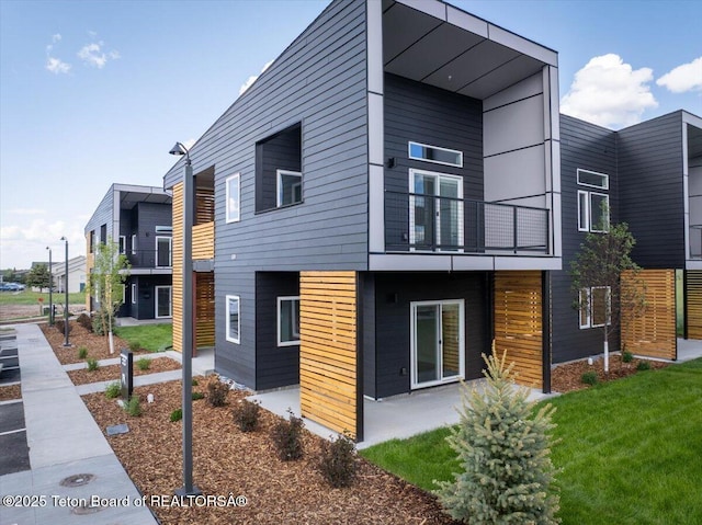 138 Larkspur Ave Unit 402, Victor, ID 83455 - view of property exterior with a balcony and a lawn