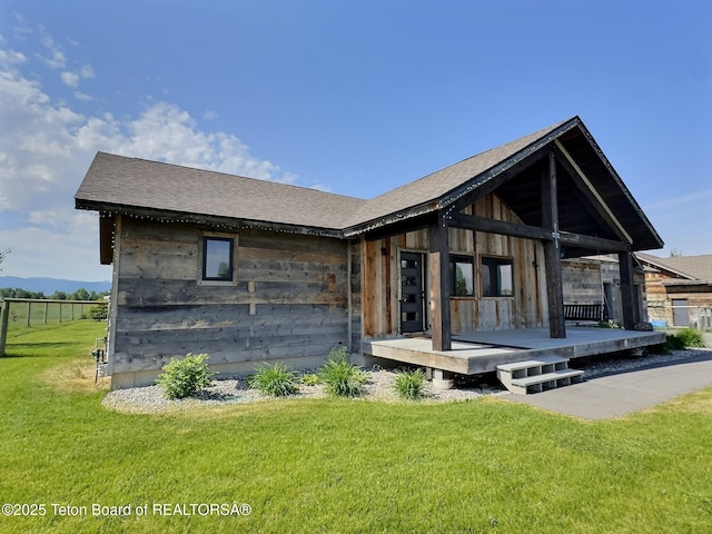 1714 River Meadows Dr, Victor, ID 83455 - back of property with a lawn, roof with shingles, and a wooden deck