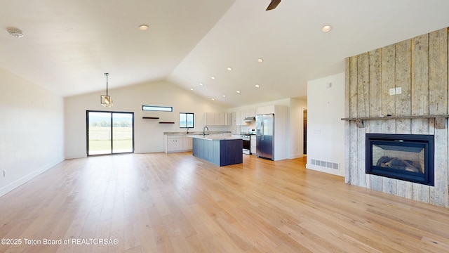 1714 River Meadows Dr, Victor, ID 83455 - unfurnished living room with a large fireplace, light wood-style floors, high vaulted ceiling, and recessed lighting