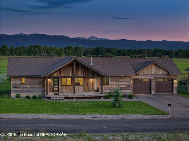 1714 River Meadows Dr, Victor, ID 83455 - view of front facade featuring a garage, a mountain view, a front yard, a porch, and driveway