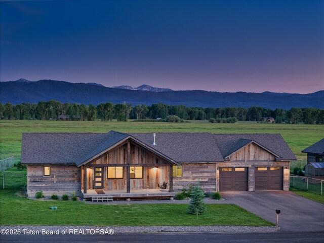 1714 River Meadows Dr, Victor, ID 83455 - view of front facade with a mountain view, a garage, asphalt driveway, and covered porch