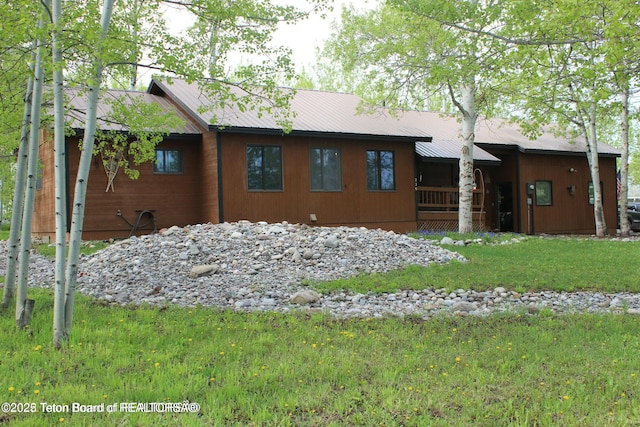 view of front of home with metal roof and a front yard