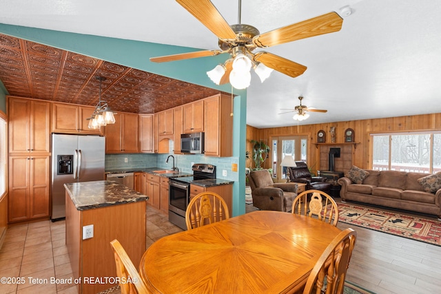 kitchen with a kitchen island, an ornate ceiling, a sink, appliances with stainless steel finishes, and tasteful backsplash
