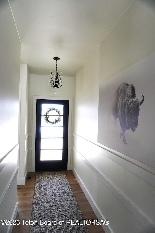 825 Mccoy Dr, Pinedale, WY 82941 - doorway to outside featuring wood finished floors and a chandelier