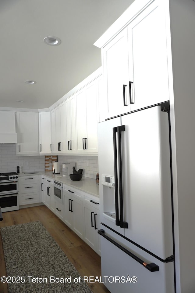 825 Mccoy Dr, Pinedale, WY 82941 - kitchen featuring double oven range, white cabinetry, tasteful backsplash, and white fridge with ice dispenser