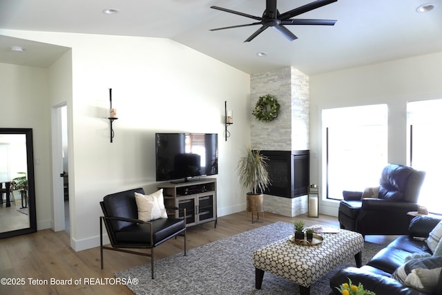 825 Mccoy Dr, Pinedale, WY 82941 - living area featuring lofted ceiling, wood finished floors, a tile fireplace, and a ceiling fan