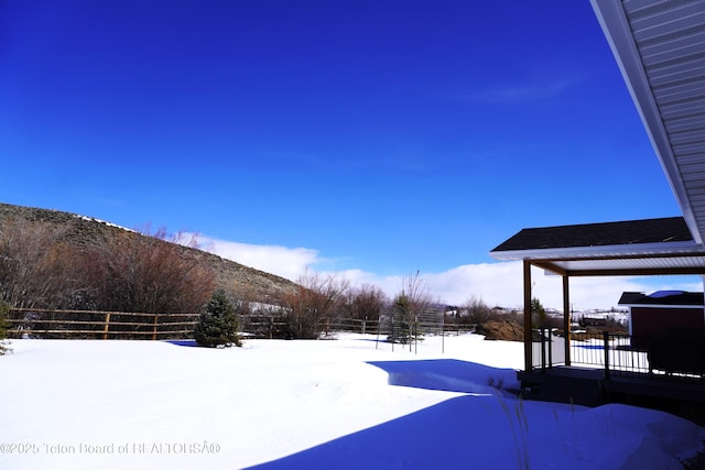 825 Mccoy Dr, Pinedale, WY 82941 - yard covered in snow with a mountain view and fence