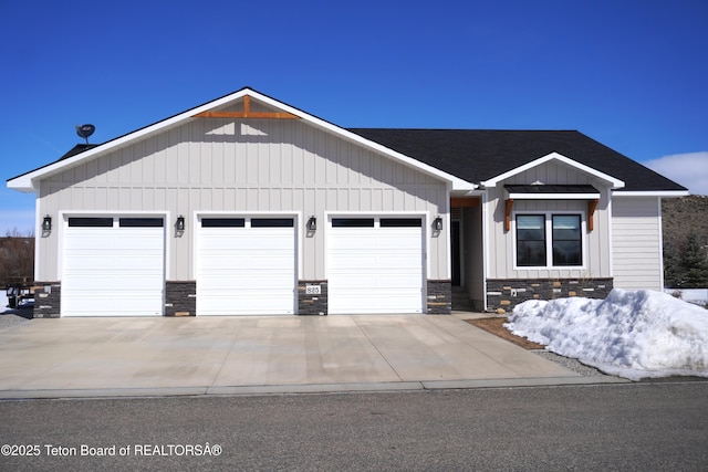 825 Mccoy Dr, Pinedale, WY 82941 - view of front facade with a shingled roof, stone siding, board and batten siding, and a garage