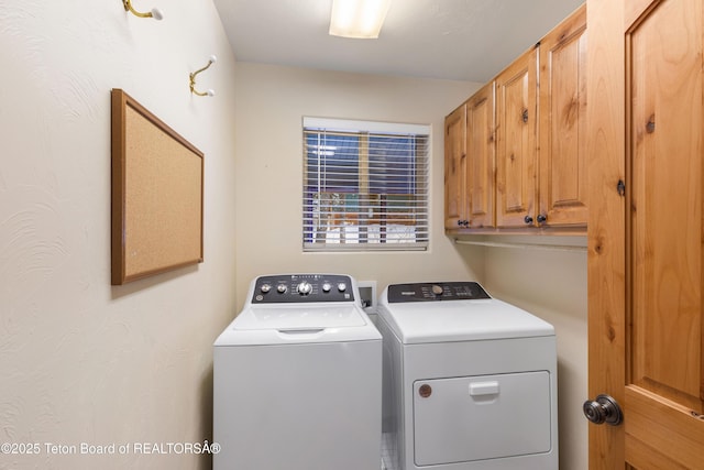 laundry room featuring washing machine and clothes dryer and cabinet space