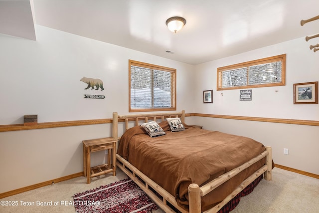 carpeted bedroom featuring baseboards and visible vents