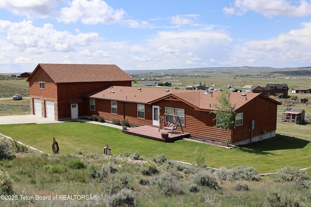 25 Vixen Cir, Pinedale, WY 82941 - rear view of property with concrete driveway, a deck, a lawn, and roof with shingles
