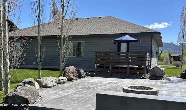 398 Palisade Trl, Driggs, ID 83422 - rear view of house with an outdoor fire pit, a deck, a patio, a lawn, and roof with shingles