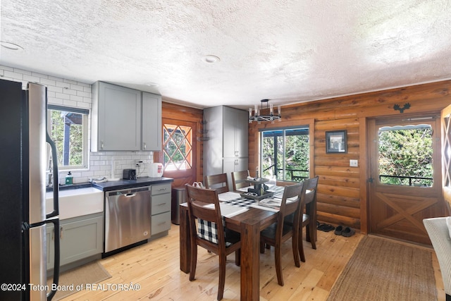 dining space featuring log walls, a textured ceiling, and light wood-style flooring