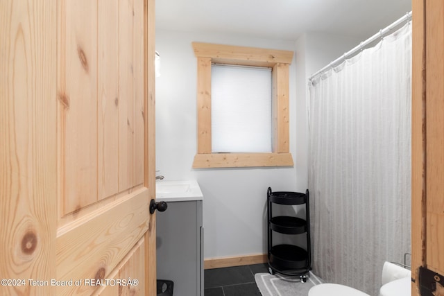 bathroom with baseboards, toilet, tile patterned floors, and vanity