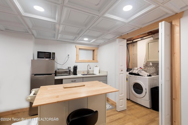 kitchen with butcher block countertops, a sink, light wood-style floors, and a toaster