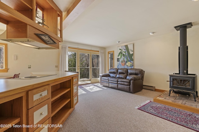 living room with baseboard heating, light carpet, and a wood stove