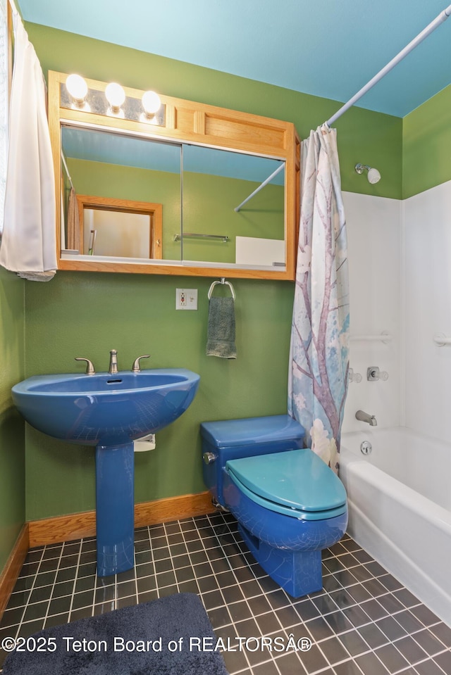 bathroom featuring baseboards, toilet, shower / tub combo, and tile patterned flooring