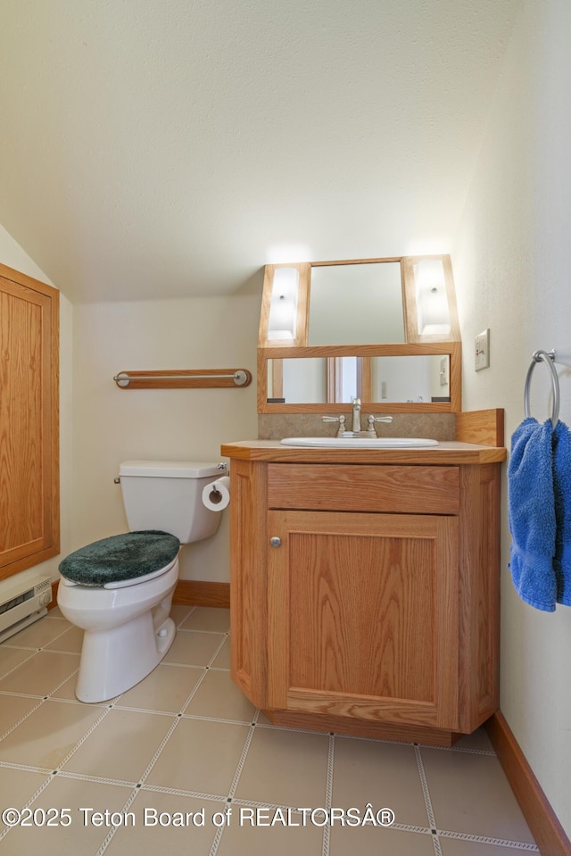 half bath featuring toilet, vanity, baseboards, and a baseboard heating unit