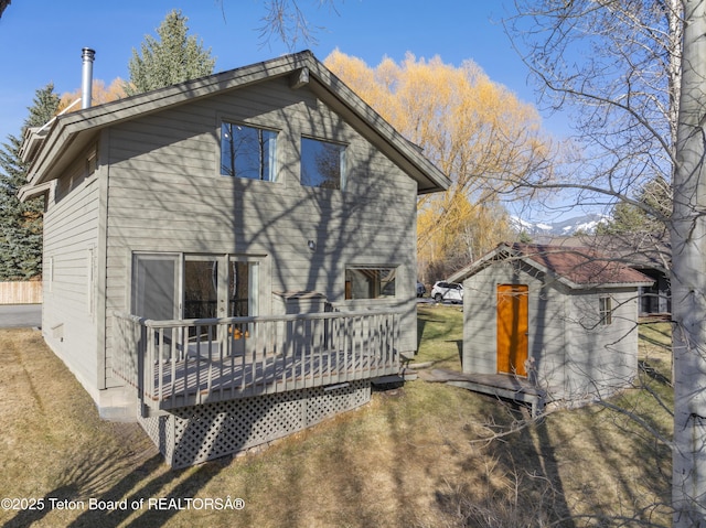 rear view of property with a deck and a yard