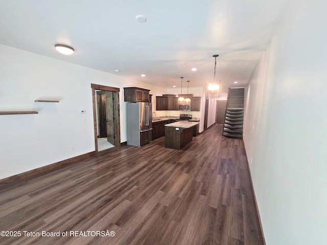 8531 Caribou Ct, Victor, ID 83455 - kitchen featuring appliances with stainless steel finishes, dark brown cabinets, dark wood-type flooring, a kitchen island, and light countertops