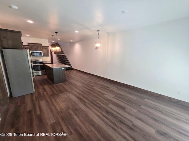 8531 Caribou Ct, Victor, ID 83455 - kitchen with stainless steel appliances, dark wood-style flooring, dark brown cabinets, a kitchen island, and recessed lighting
