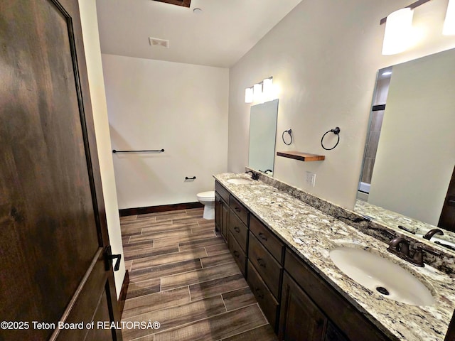 8531 Caribou Ct, Victor, ID 83455 - bathroom with wood tiled floors, double vanity, toilet, and baseboards