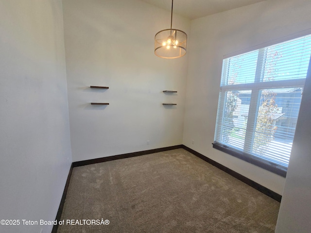 8531 Caribou Ct, Victor, ID 83455 - carpeted spare room with baseboards and a chandelier