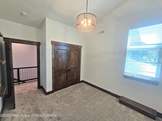 8531 Caribou Ct, Victor, ID 83455 - unfurnished bedroom with carpet floors, a chandelier, and baseboards