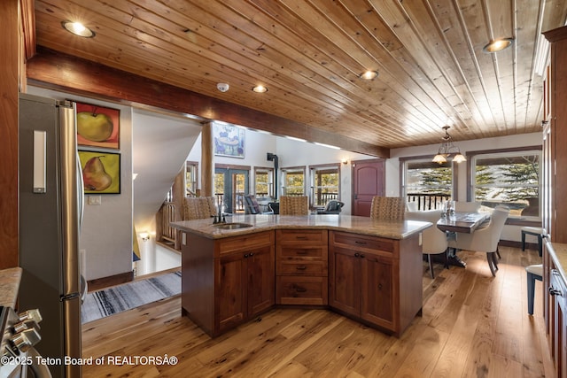 980 S 1000 E, Driggs, ID 83455 - kitchen with hanging light fixtures, a sink, light wood finished floors, freestanding refrigerator, and brown cabinets