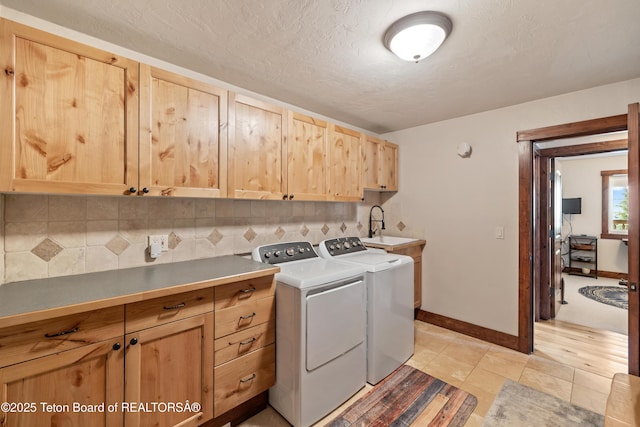 980 S 1000 E, Driggs, ID 83455 - laundry area featuring a sink, a textured ceiling, baseboards, washer and dryer, and cabinet space