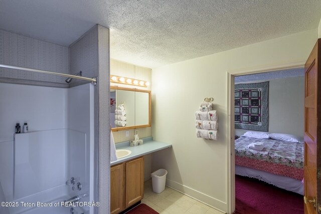 full bath featuring vanity, baseboards, bathtub / shower combination, a textured ceiling, and connected bathroom