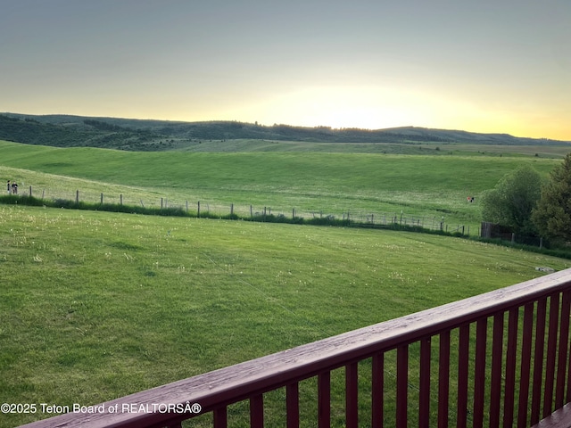 view of yard featuring a rural view, a mountain view, and fence
