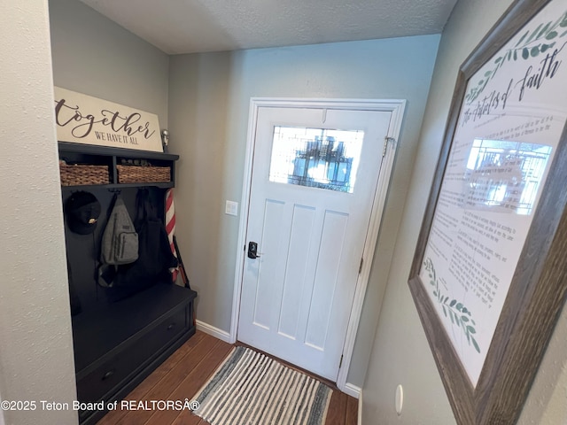mudroom featuring baseboards, wood finished floors, and a textured ceiling