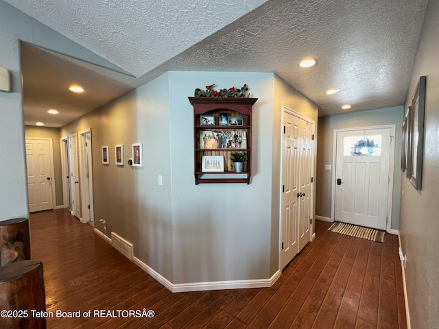 hall featuring visible vents, baseboards, recessed lighting, and dark wood-style floors