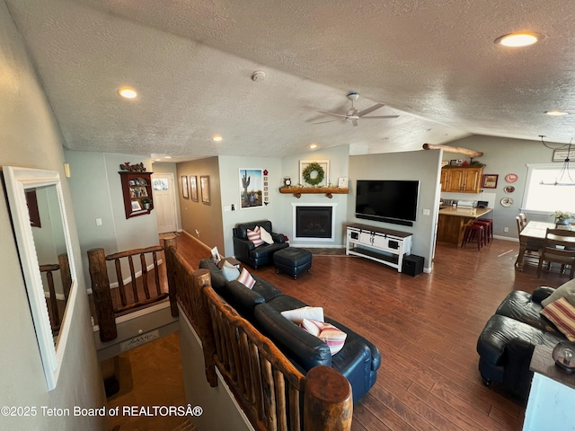 living area with dark wood-style flooring, vaulted ceiling, recessed lighting, a textured ceiling, and ceiling fan