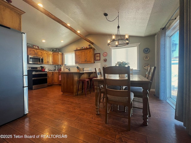 dining room with a healthy amount of sunlight, dark wood-style flooring, an inviting chandelier, and lofted ceiling
