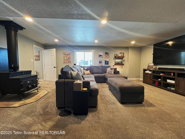carpeted living area featuring a textured ceiling, a wood stove, baseboards, and recessed lighting