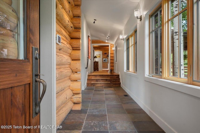 3300 N Trapper Ln, Wilson, WY 83014 - hallway featuring rustic walls, healthy amount of natural light, dark stone finish floors, and stairs