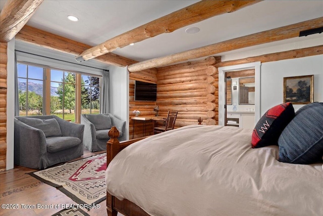 3300 N Trapper Ln, Wilson, WY 83014 - bedroom with log walls, beam ceiling, wood finished floors, recessed lighting, and ensuite bath