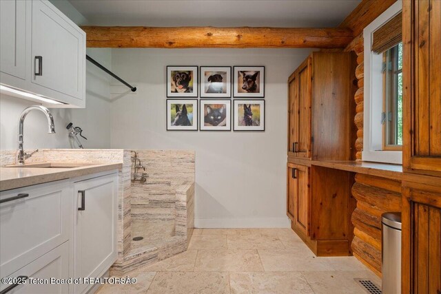 3300 N Trapper Ln, Wilson, WY 83014 - laundry area featuring log walls and light stone finish floors