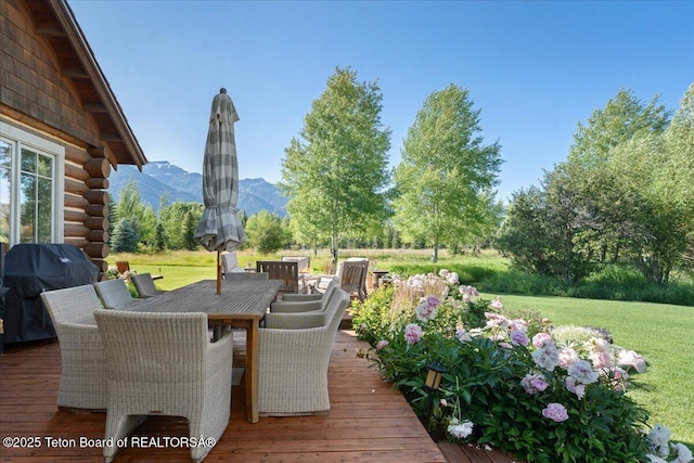 3300 N Trapper Ln, Wilson, WY 83014 - wooden deck with a mountain view, outdoor dining space, a lawn, and grilling area