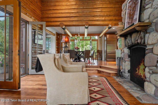 3300 N Trapper Ln, Wilson, WY 83014 - living area featuring wood finished floors, rustic walls, a fireplace, and a towering ceiling