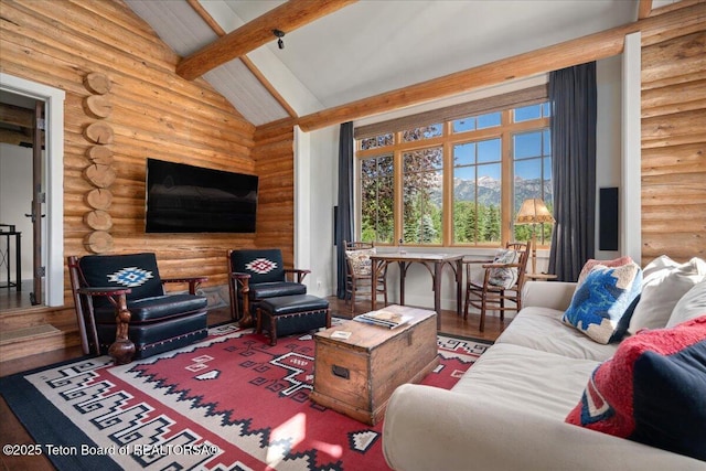 3300 N Trapper Ln, Wilson, WY 83014 - living room with log walls, beamed ceiling, wood finished floors, and high vaulted ceiling