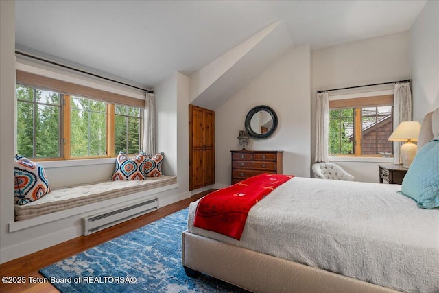 3300 N Trapper Ln, Wilson, WY 83014 - bedroom featuring baseboard heating, vaulted ceiling, and wood finished floors