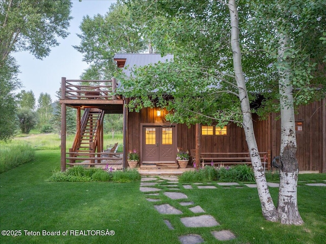 3300 N Trapper Ln, Wilson, WY 83014 - rear view of property with stairway, a wooden deck, a yard, board and batten siding, and a metal roof