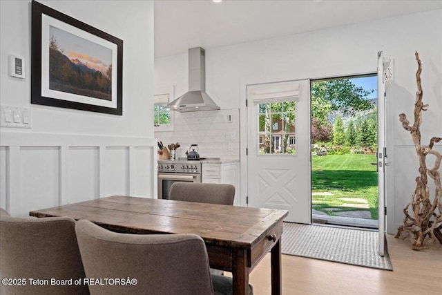 3300 N Trapper Ln, Wilson, WY 83014 - dining space with light wood-type flooring and a wainscoted wall