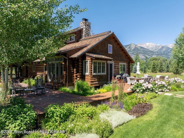 3300 N Trapper Ln, Wilson, WY 83014 - rear view of house with french doors, a chimney, a deck with mountain view, and log siding